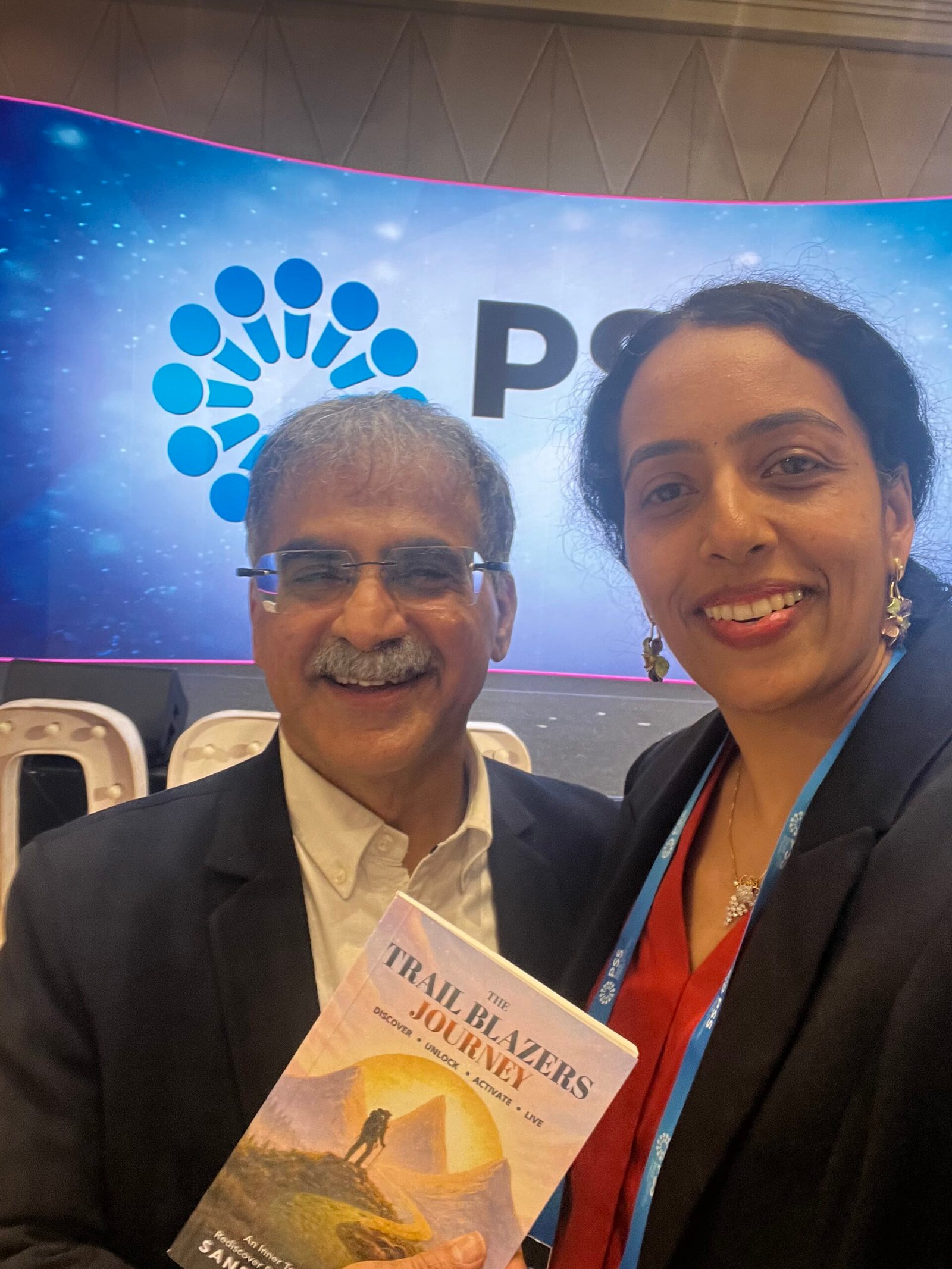 Sandhya Rudraraju with a global leader holding The Trail Blazers Journey