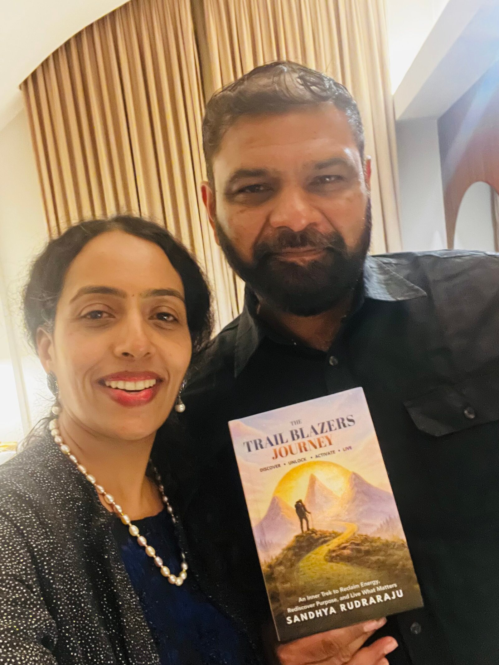 Sandhya Rudraraju with a global leader holding The Trail Blazers Journey