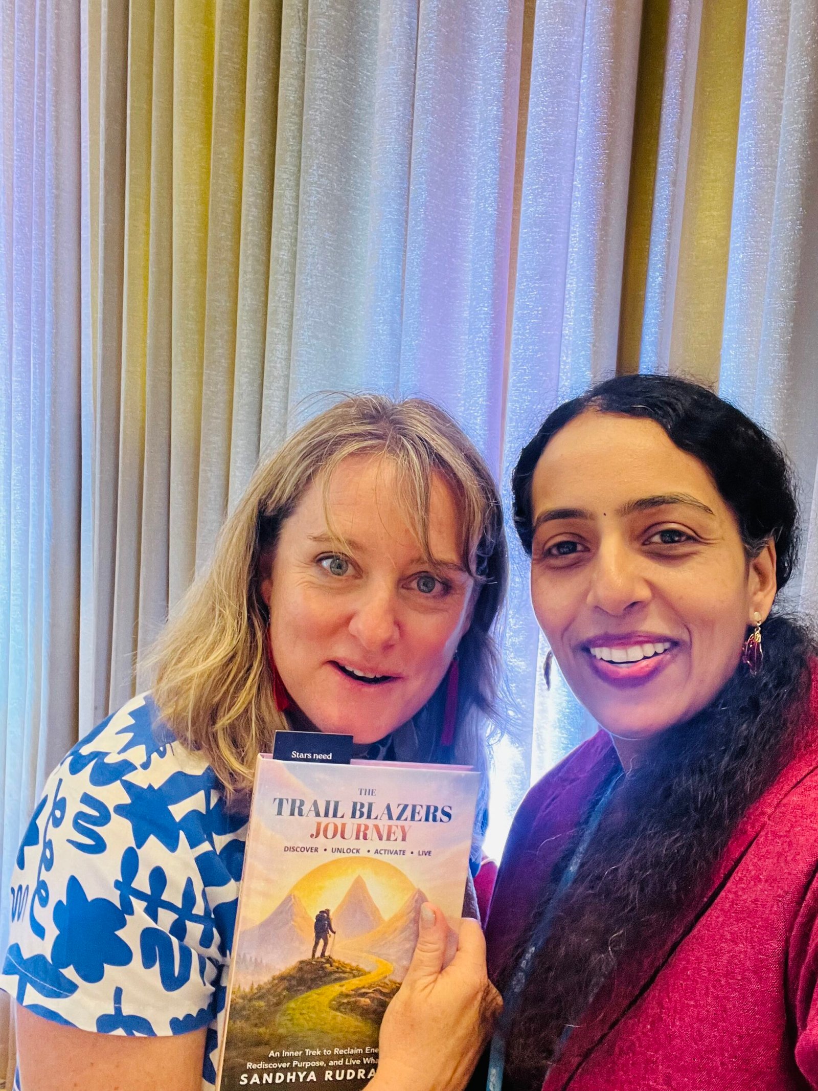 Sandhya Rudraraju with a global leader holding The Trail Blazers Journey