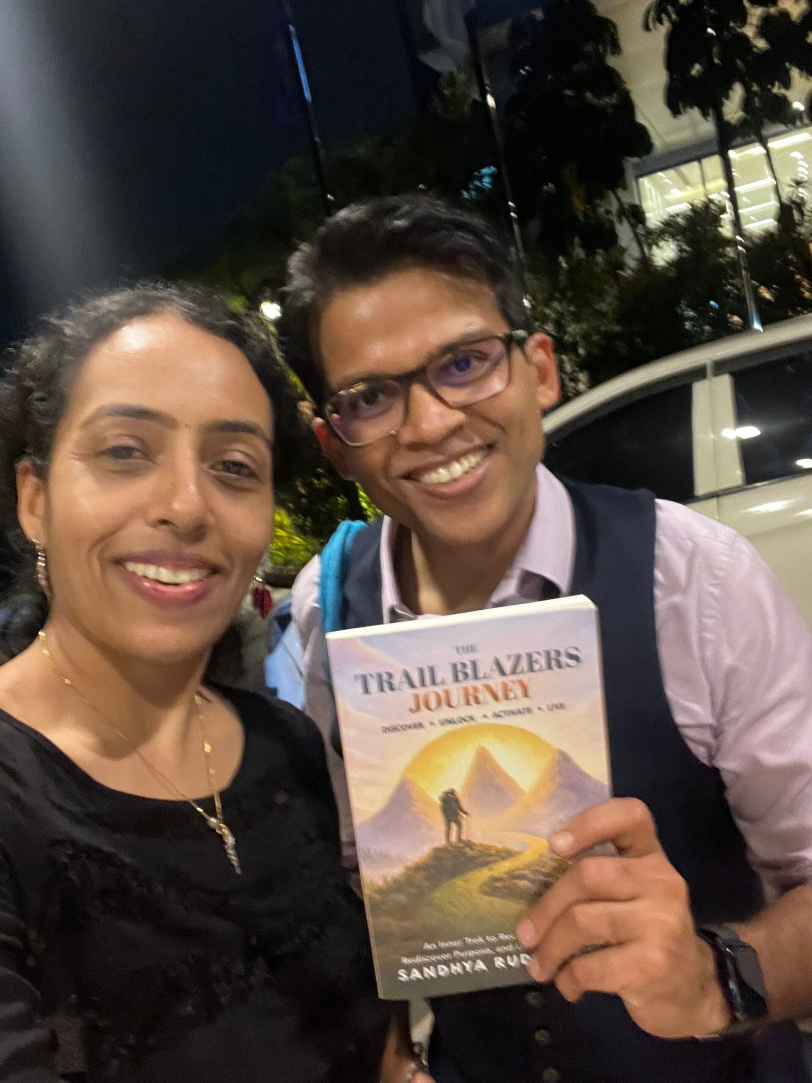 Sandhya Rudraraju with a global leader holding The Trail Blazers Journey