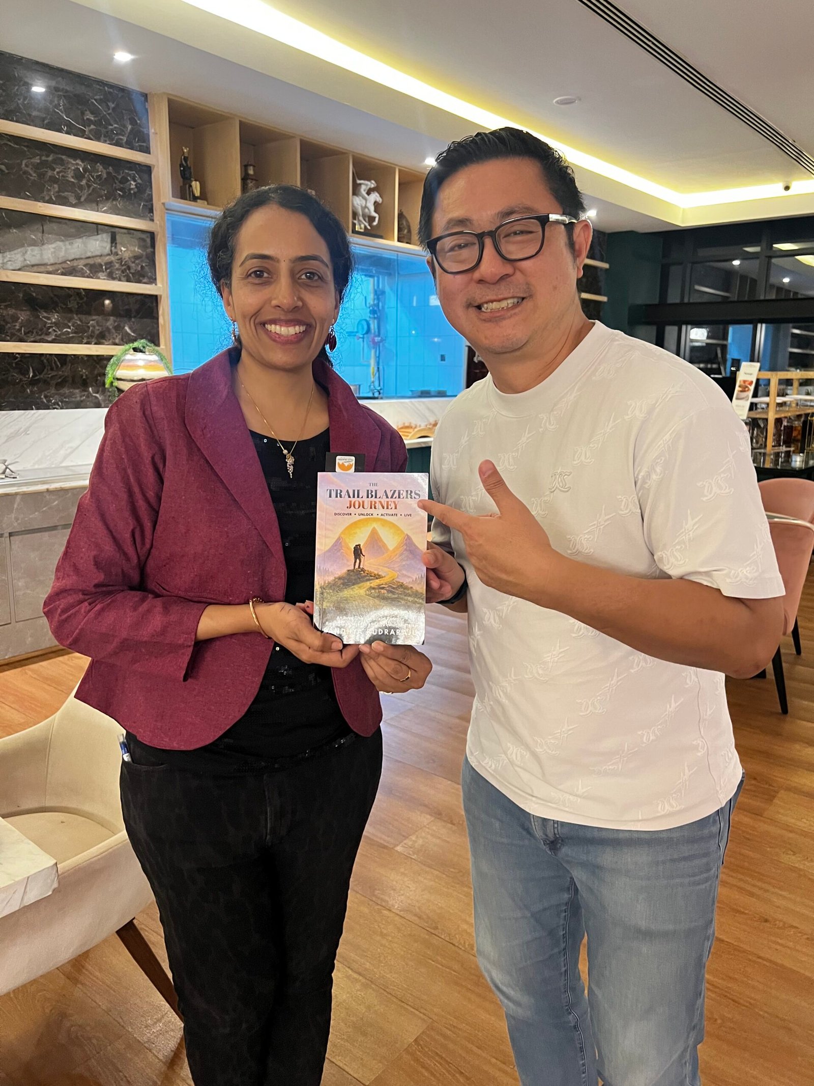Sandhya Rudraraju with a global leader holding The Trail Blazers Journey