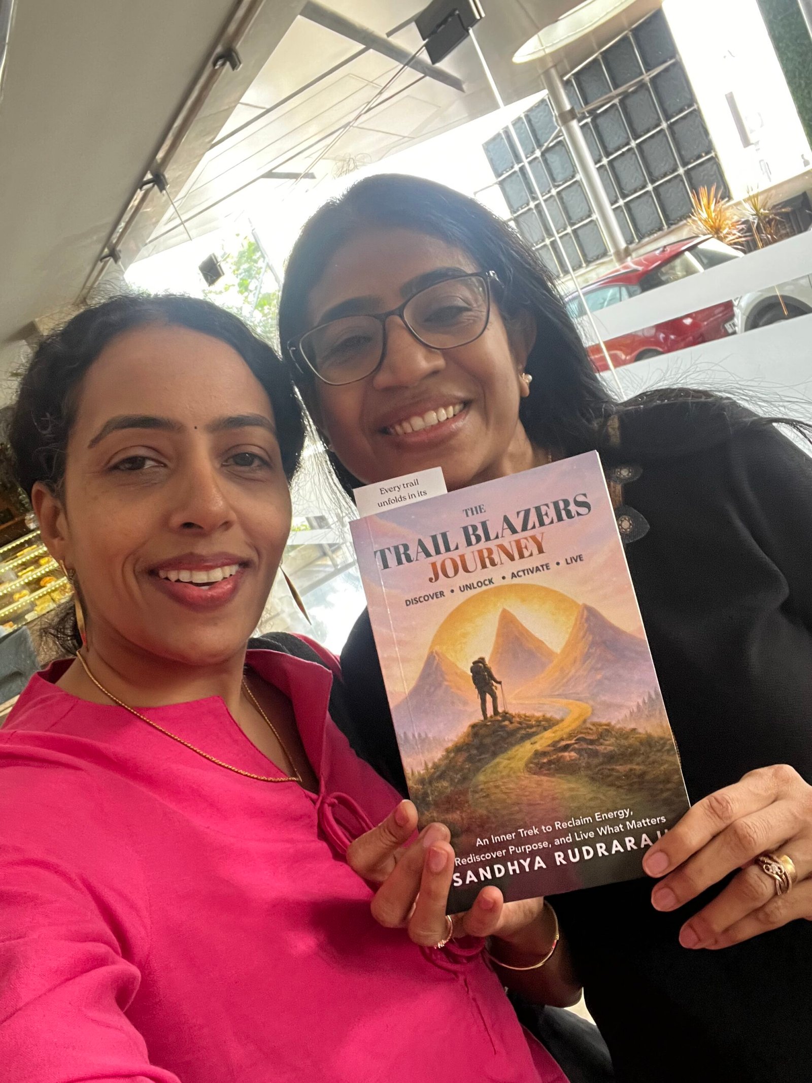 Sandhya Rudraraju with a global leader holding The Trail Blazers Journey