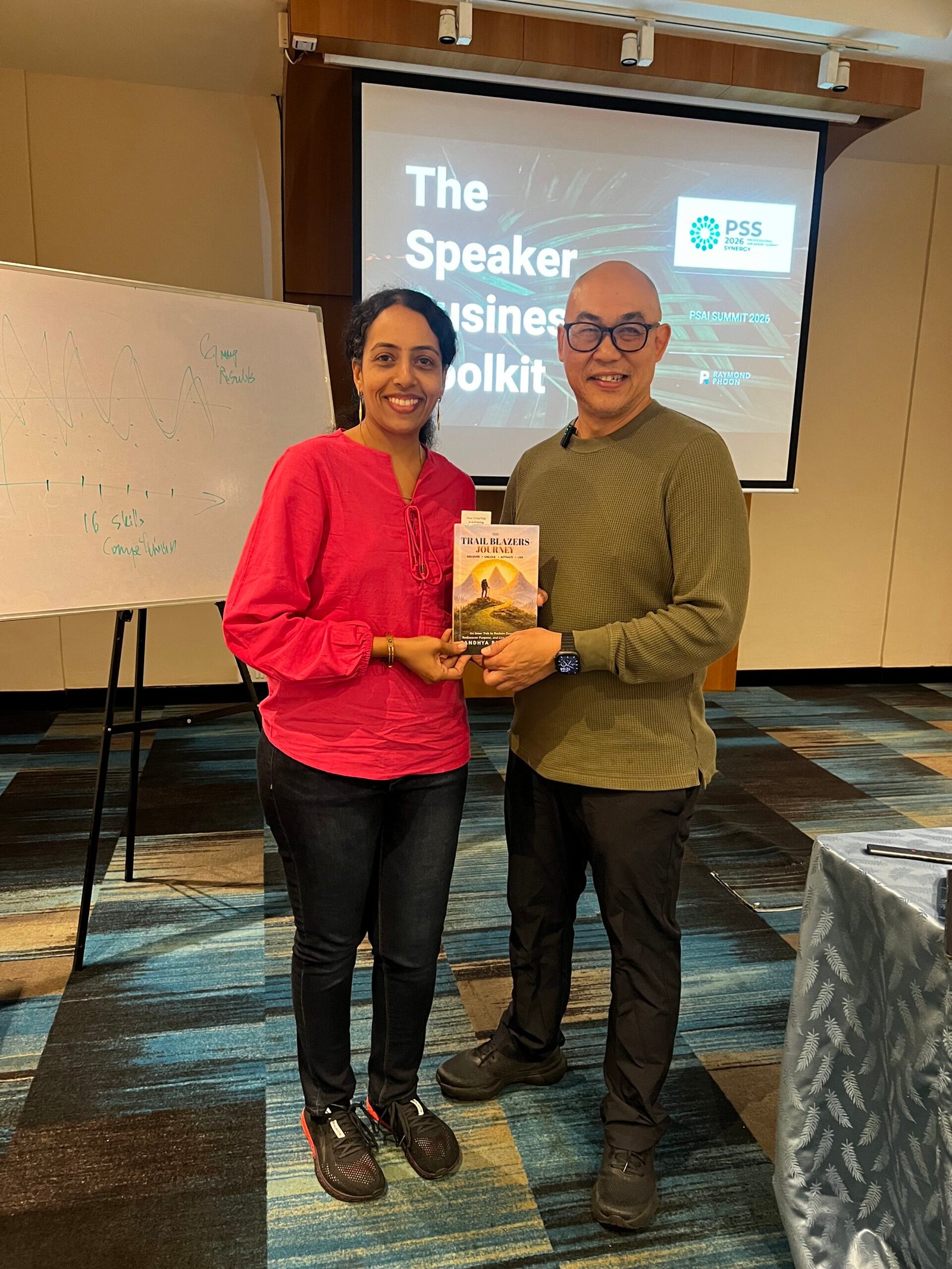 Sandhya Rudraraju with a global leader holding The Trail Blazers Journey